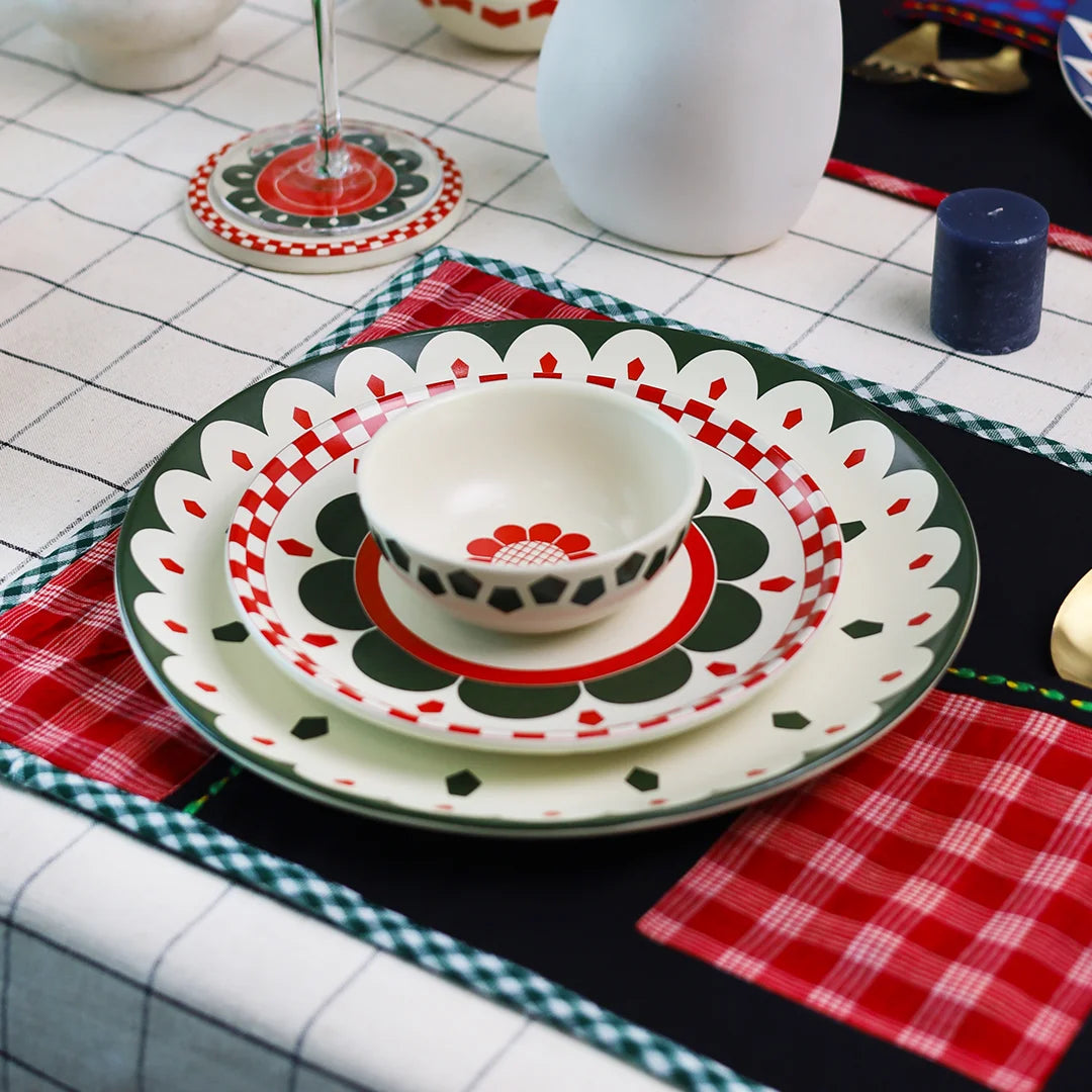 Kolkata inspired ceramic dinnerware set on a red and black table mat 