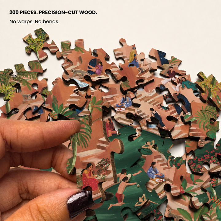 A hand holds a pile of 200 precision-cut wooden jigsaw puzzle pieces featuring a tropical beach scene with people, on a light background with text at the top.